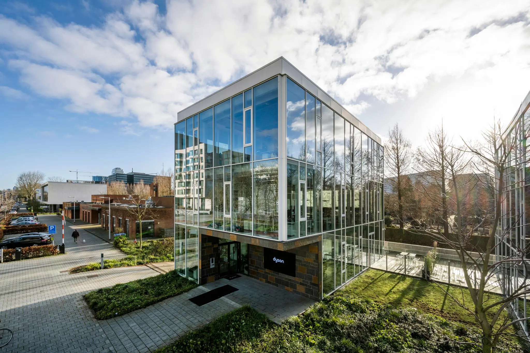 Modern kantoorgebouw met glazen gevel aan de Fred. Roeskestraat in Amsterdam, met het logo van Dyson bij de ingang.